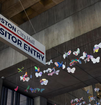 Butterflies to the right of a Visitor sign on the 3rd floor of Boston City Hall